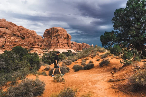 Hombre Caminando Desierto Seco Con Arbustos Verdes Bajo Cielo Nublado — Foto de Stock