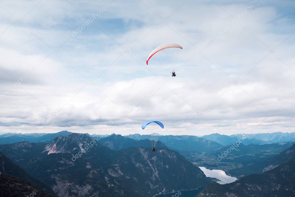 Paragliding over the lake in Austrian Alps: Magnificent view of blue sea with rocky mountains during sunrise