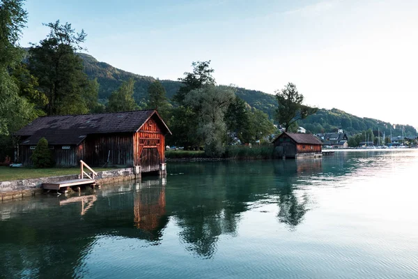 Wooden houses near lake surrounded with mountains in Austria