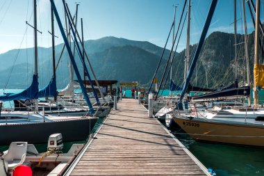 Avusturya, büyüleyici rocky Dağları ile mavi göl manzarasına iskelede Yatlar demirli 