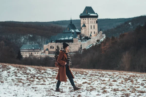 Karlstejn castle, Çek Cumhuriyeti: genç hipster kadın ünlü kalenin önünde yürür