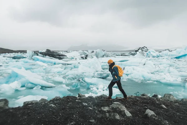 站在被浮冰覆盖的海边的年轻女孩看着冰岛的北欧风景 — 图库照片