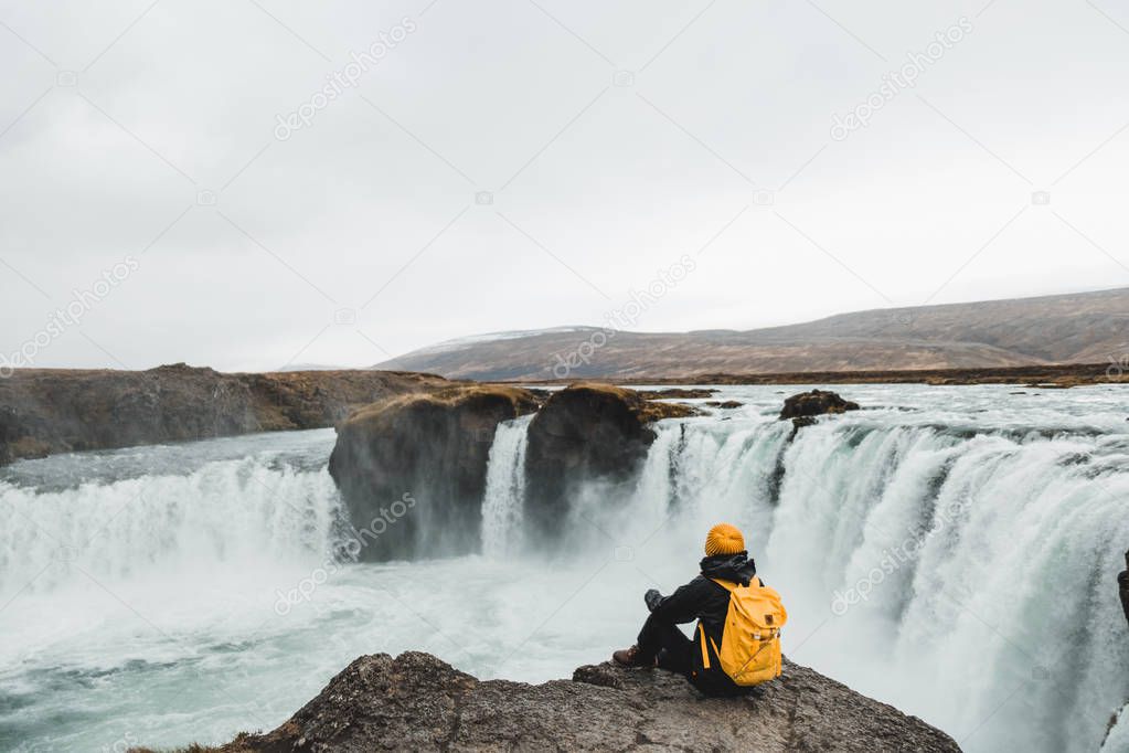 woman looking at picturesque waterfall, Iceland. Nordic nature