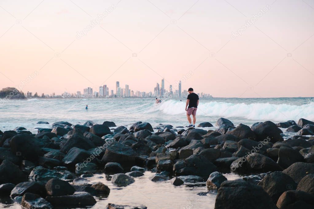 Man waling on the rocks on the sea