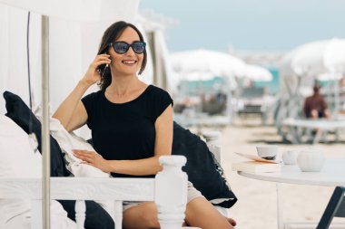 Genç bir kadın beach Cafe telefonda konuşuyor