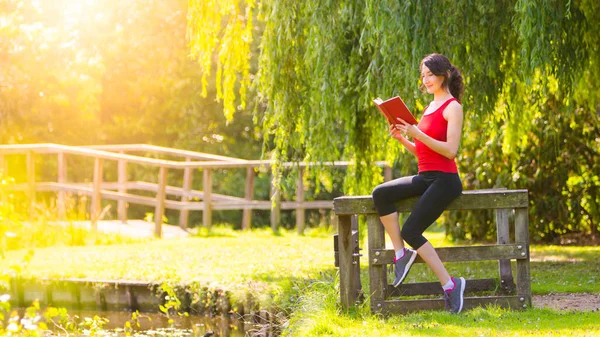 Attraktiva Fit Ung Kvinna Läser Bok Parken Soliga Skott Sportig — Stockfoto