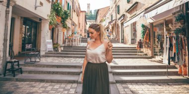 Europe fun, summer happy romantic woman in vacation in Italy, Santarcangelo Di Romagna - portrait of curvy blonde hair woman walking in typical italian old city center - travel and relaxing concept clipart
