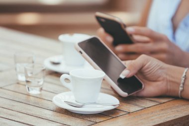 Erkek Close-up sosyal ağ üzerinde sohbet veya Cafe iki İtalyan espresso kahve fincan ile online alışveriş holding telefonu eller. Kompulsif akıllı telefon ve internet kullanım (bağımlılık) Restoran