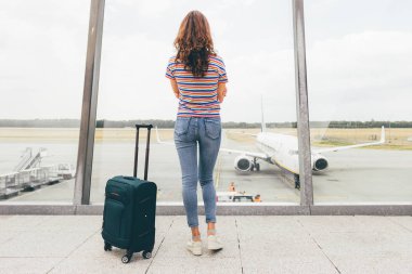 Onu uçuş havaalanında onu el bagajı (yeşil arabası) ile (sadece sonra görev ücretsiz) lounge salonunda bekleyen genç ince kadın. Kaybolan veya iptal edilen uçuş, gerek tazminat kavramı. Eindhoven, Hollanda