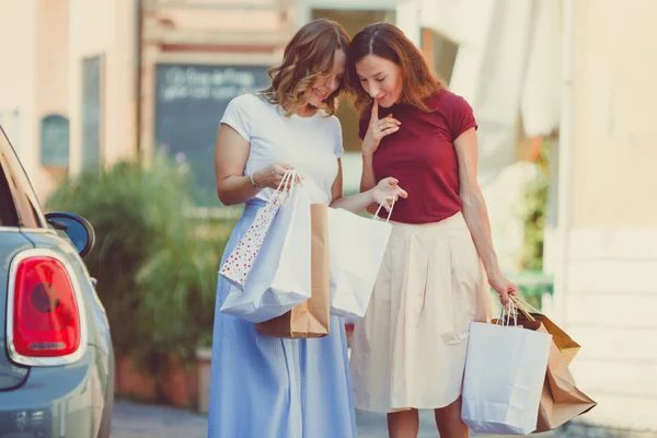 Best Girlfriends Showing Purchases Shopper Bags Each Other Looking Curiously — Stock Photo, Image