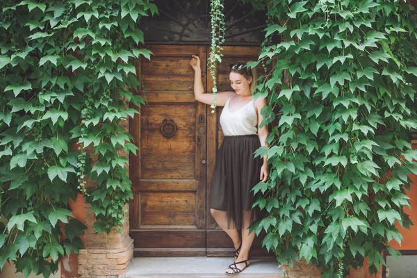 Young curvy female model on typical Italian ancient urban background