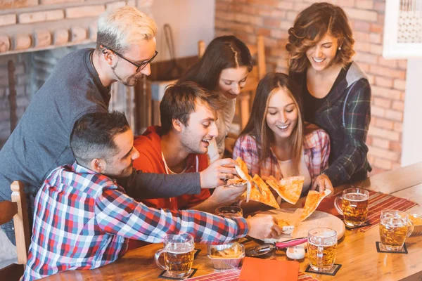 Genç grup insanlar eğleniyor, yemek pizza ve içki bira birlikte - gençler arkadaş enjoing parti ve kutluyor