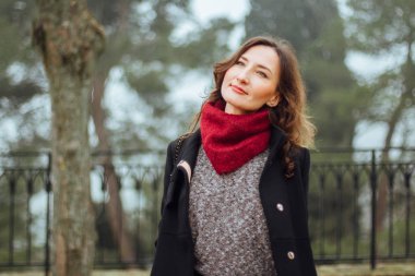 Sonbahar ya da kış yeşil sisli arka plan üzerinde genç romantik ve gülümseyen kadın