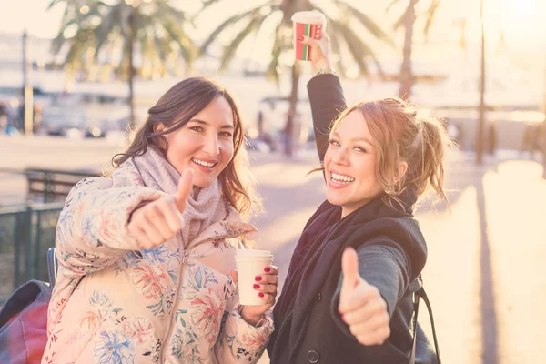 Due Giovani Donne Sorridenti Attraenti Fare Pollice Gesto Tenendo Caffè — Foto Stock