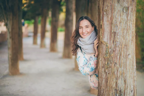 Bir Ağacın Arkasına Saklanarak Genç Gülümseyen Kadın — Stok fotoğraf