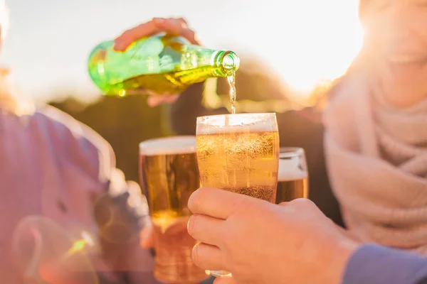 ビールを飲むと楽しい グリーン ボトルからの笑みを浮かべて少女注ぐビール若い幸せな友人のグループ — ストック写真