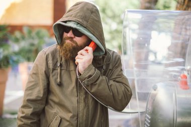 Genel telefon hoodie (ceket) ve siyah güneş gözlüğü - muhbir, casus, gizli ajan ve sahte haber kavramı kullanan genç sakallı adam portresi