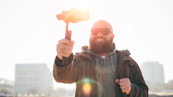 Yapma smartphone ve sabitleyici, blogger veya etki unsuru kavramı ile video yakışıklı sakallı adam portresi