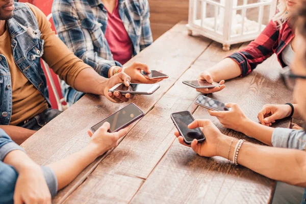 Группа Друзей Тысячелетия Держащих Смартфоны Сидящие Столом Поколение Социальные Сети — стоковое фото