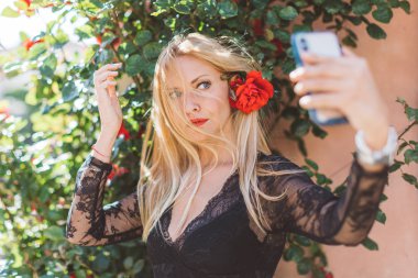 Güzel İskandinav sarışın kadın akıllı telefon ile selfie yaparken saçları ile ilgili bir sorun yaşıyor