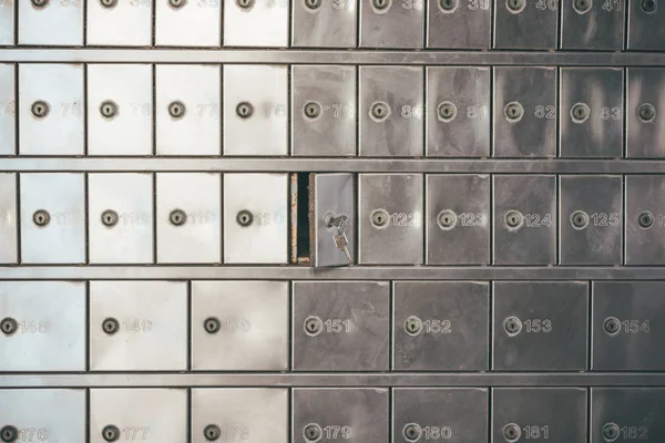 Private bank deposit box - close up of opened mailbox with a small key - post office box or PO BOX concept