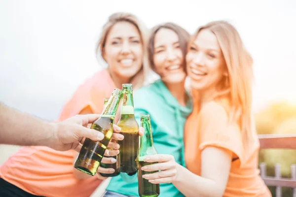 緑のビールボトルがクリンキング 屋上の夏のパーティー 幸せな友人が乾杯し 手に焦点を当てます — ストック写真