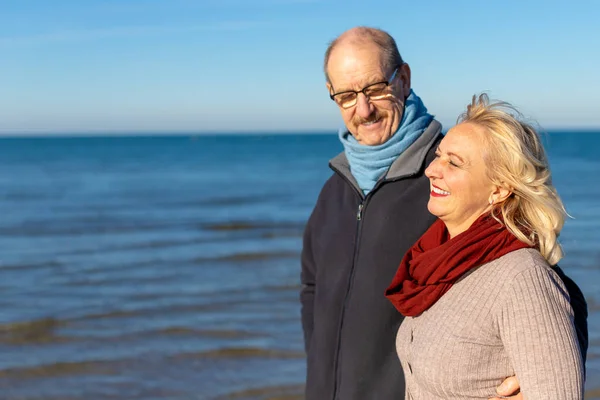 Portrait of happy senior couple on sea background - retirement, healthy lifestyle concept
