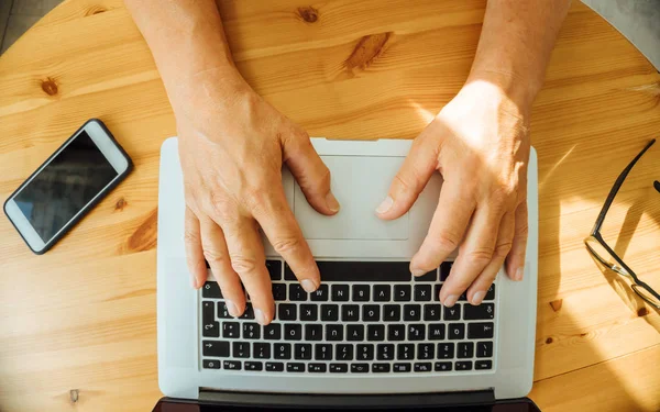 Kucak üst klavye yaşlı adamın ellerini üst görünümü - evde çalışan üst düzey insanlar, pc ve akıllı telefon konsepti kullanarak - düz yatıyordu resim