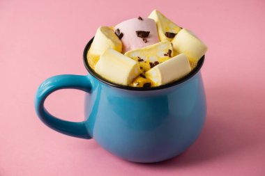 Pembe bir arka planda mavi bardak ve kakao Marshmallow