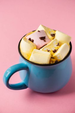Pembe bir arka planda mavi bardak ve kakao Marshmallow