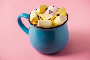 Pembe bir arka planda mavi bardak ve kakao Marshmallow