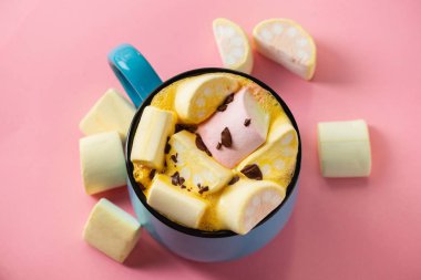 Pembe bir arka planda mavi bardak ve kakao Marshmallow