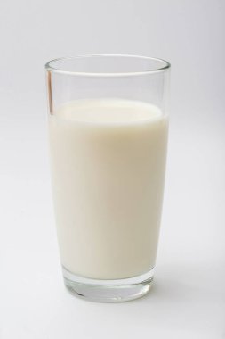 Beyaz arka planda bir bardak süt.