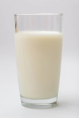 Beyaz arka planda bir bardak süt.