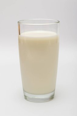 Beyaz arka planda bir bardak süt.