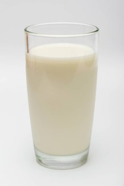 Beyaz arka planda bir bardak süt.
