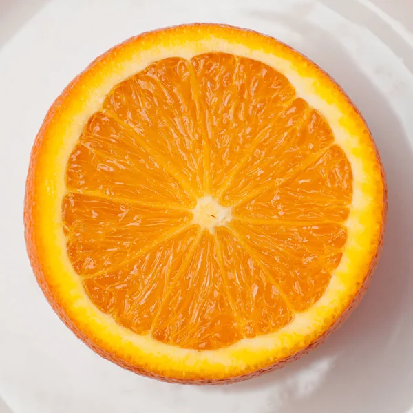 orange in a cut on a white plate