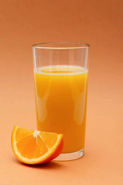 Een Glas Jus Orange Een Oranje Achtergrond Met Een Plakje — Stockfoto