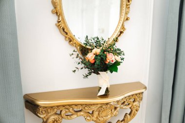Gelinler düğün buketi Aynanın yanındaki altın masada