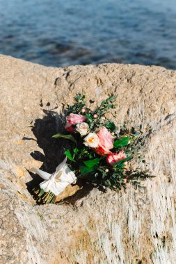 Gün batımında deniz kenarında bir gelin buketi.