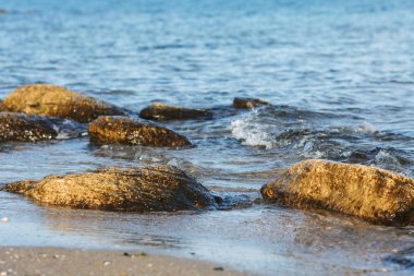 Baharda gün batımında kayalık plaj