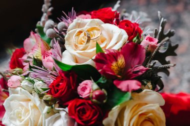 Gelinin buketindeki alyanslar mermer pencere eşiğinde.