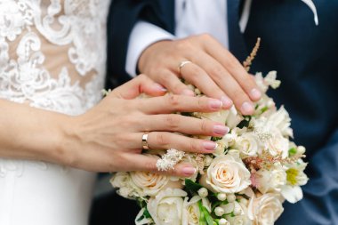 gelin buketi üzerinde halkalar ile eller yeni evliler