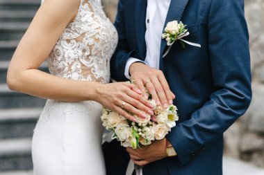 gelin buketi üzerinde halkalar ile eller yeni evliler