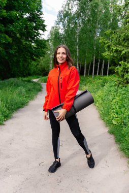 Kırmızı ceketli genç bir kız doğada eğitime gider.