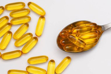 Beyaz zemin üzerinde omega-3 balık yağı kapsülleri