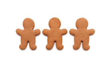 Beyaz arka planda izole edilmiş erkek şeklinde üç zencefilli kurabiye.