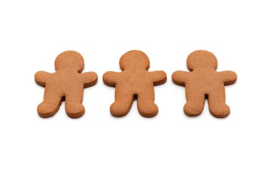 Beyaz arka planda izole edilmiş erkek şeklinde üç zencefilli kurabiye.