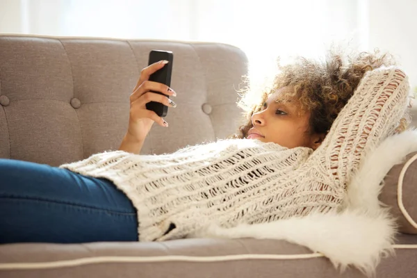 Portret Van Afro Amerikaanse Vrouw Liggend Bank Zoek Mobiele Telefoon — Stockfoto