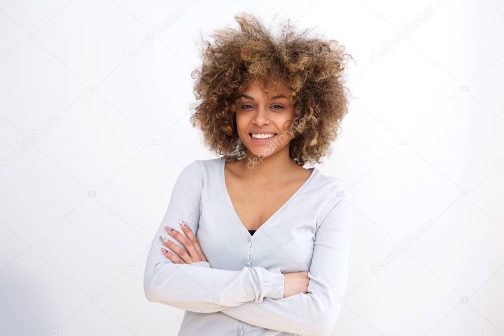 Portrait of confident young african american woman smiling against white background with arms crossed